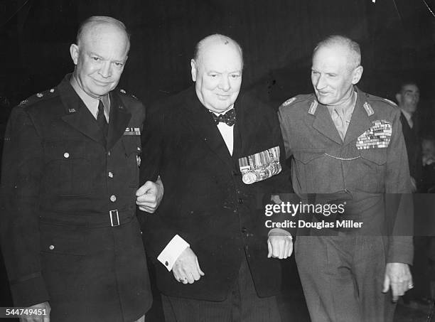 General Eisenhower and Field Marshal Viscount Montgomery assisting Winston Churchill , after the latter's speech at Empress Hall, London, October...