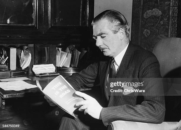 British Prime Minister Sir Anthony Eden reading his party's campaign pamphlet 'This is the Road', 1950.