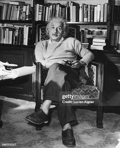 Portrait of physicist Albert Einstein sitting in an armchair with a pipe, circa 1934.