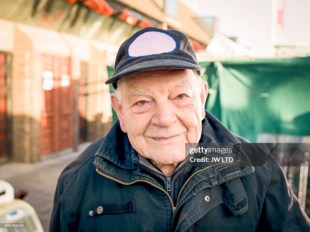 Portrait of senior smiling to camera, urban enviro