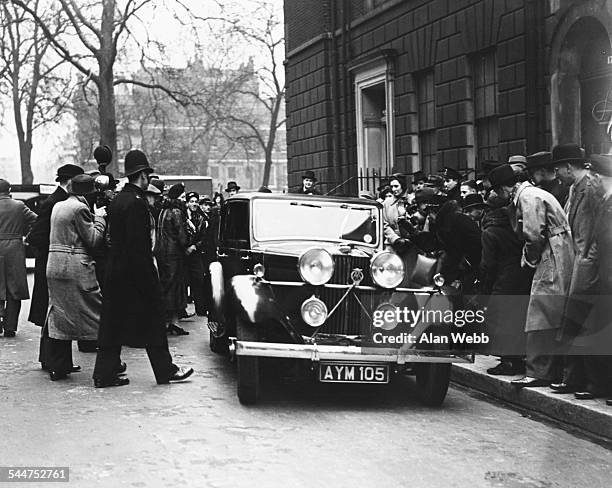 British politician Sir Anthony Eden arriving at the House of Commons in his car, being greeted by a large group of the press and public as he...