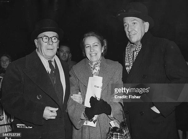 Playwright Noel Coward with actor Roland Young and his wife at Waterloo Station, London, December 8th 1950.