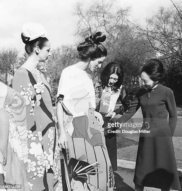 Madame Yukawa , wife of the Japanese Ambassador, talking to designer Hanae Mori and a group of models, during a private fashion show in the garden of...