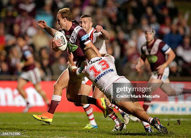 Daly Cherry-Evans of the Sea Eagles is tackled during the round 17 NRL match between the Manly Sea Eagles and the St George Illawarra Dragons at...