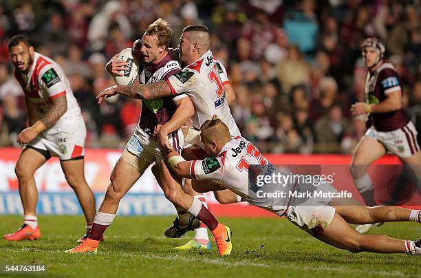 Daly Cherry-Evans of the Sea Eagles is tackled during the round 17 NRL match between the Manly Sea Eagles and the St George Illawarra Dragons at...