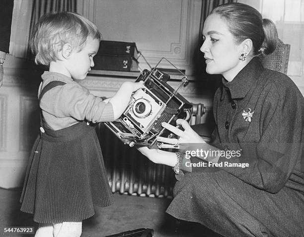 Actress Patrice Wymore showing her young daughter Arnella a camera, while London to film 'The Errol Flynn Theatre', in their room at the Savoy Hotel,...