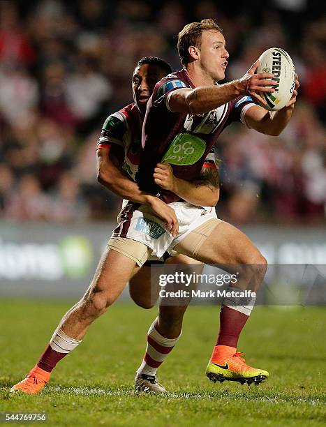 Daly Cherry-Evans of the Sea Eagles is tackled by Benji Marshall of the Dragons during the round 17 NRL match between the Manly Sea Eagles and the St...