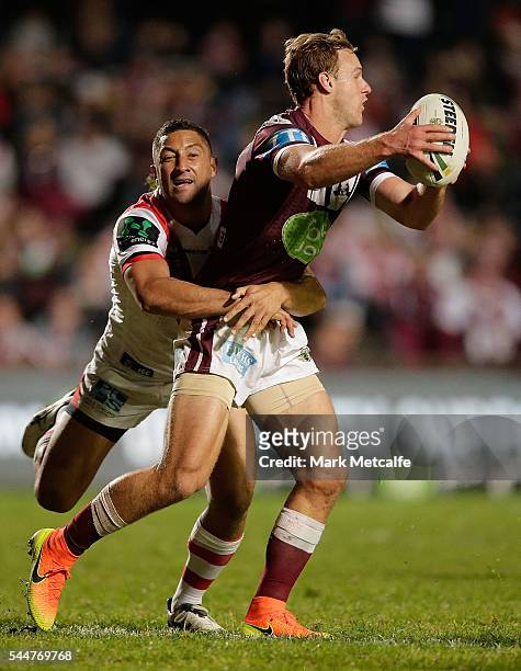 Daly Cherry-Evans of the Sea Eagles is tackled by Benji Marshall of the Dragons during the round 17 NRL match between the Manly Sea Eagles and the St...