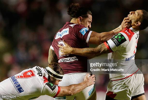 Jorge Taufua of the Sea Eagles is tackled by Mitch Rein and Benji Marshall of the Dragons during the round 17 NRL match between the Manly Sea Eagles...
