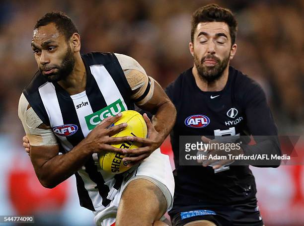 Travis Varcoe of the Magpies is tackled by Kade Simpson of the Blues during the 2016 AFL Round 15 match between the Carlton Blues and the Collingwood...