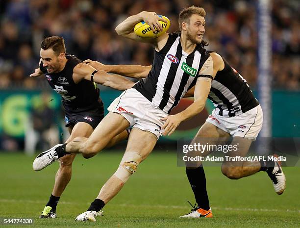 Ben Reid of the Magpies in action ahead of Andrew Walker of the Blues and Brodie Grundy of the Magpies during the 2016 AFL Round 15 match between the...