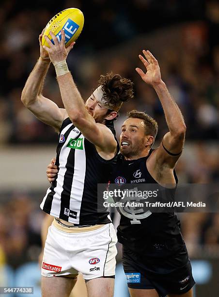 Tyson Goldsack of the Magpies marks the ball over Andrew Walker of the Blues during the 2016 AFL Round 15 match between the Carlton Blues and the...