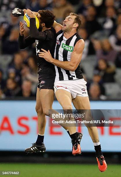 Kade Simpson of the Blues marks the ball ahead of Travis Cloke of the Magpies during the 2016 AFL Round 15 match between the Carlton Blues and the...