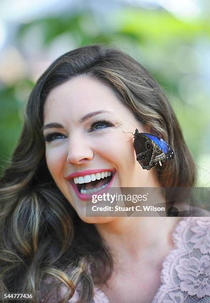 Kelly Brook poses with exotic butterflies during the launch of the RHS Hampton Court Flower Show at Hampton Court Palace on July 4, 2016 in London,...