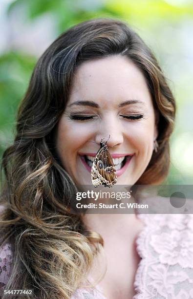 Kelly Brook poses with exotic butterflies during the launch of the RHS Hampton Court Flower Show at Hampton Court Palace on July 4, 2016 in London,...