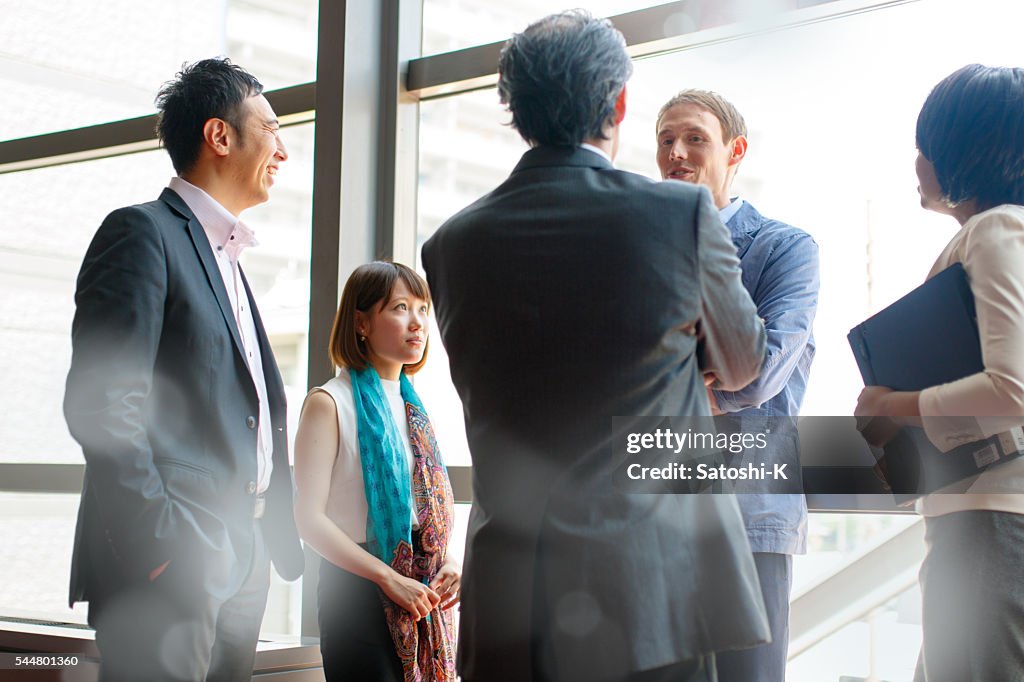 International business people doing scrum meeting by the window