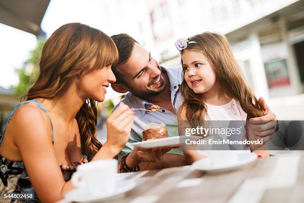 young loving family having fun in a cafe eating cake. - teenagers eating with mum stock pictures, royalty-free photos & images