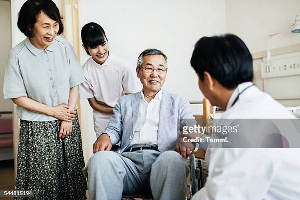 senior patient in wheelchair with family and doctor - assisted living community stock pictures, royalty-free photos & images