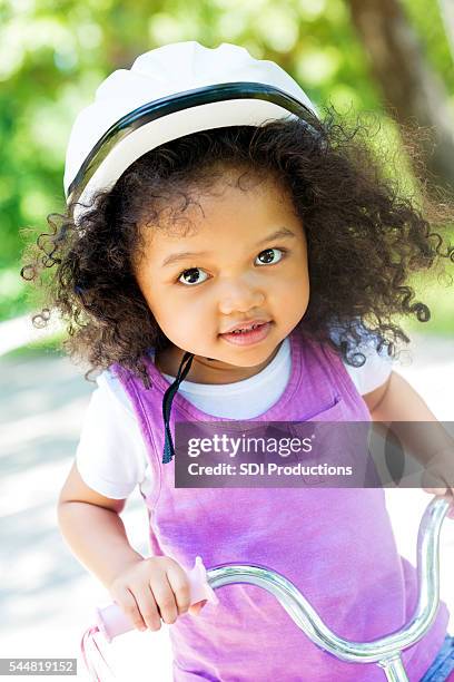 smiling toddler girl on a tricycle in the park - tricycle stock pictures, royalty-free photos & images