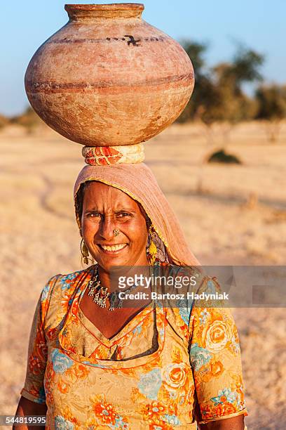 indian woman carrying water from lake - clay earring stock pictures, royalty-free photos & images