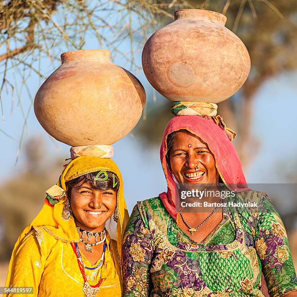 indian women carrying water from lake - clay earring stock pictures, royalty-free photos & images