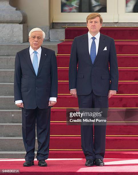 Greek President Prokopis Pavlopoulos and King Willem-Alexander of The Netherlands listen to the Greek national anthem at the Noordeinde Palace at the...