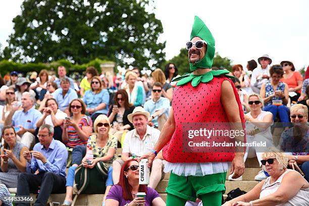 Man dressed as a strawberry watches on from Murray mound on day seven of the Wimbledon Lawn Tennis Championships at the All England Lawn Tennis and...