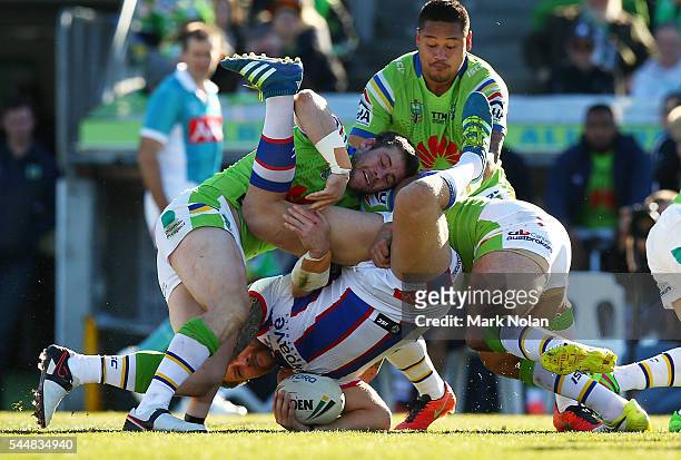 Korbin Sims of the Knights is up ended in a tackle during the round 17 NRL match between the Canberra Raiders and the Newcastle Knights at GIO...