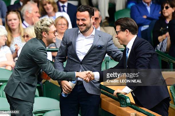 One Direction star Niall Horan shakes hands with comedian Michael McIntyre on centre court on the eighth day of the 2016 Wimbledon Championships at...