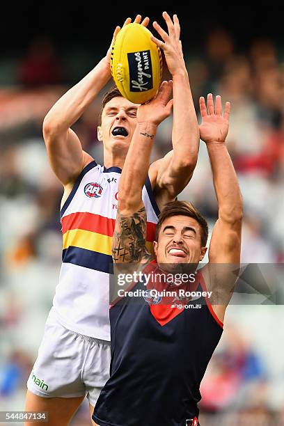 Jake Lever of the Crows marks over the top of Ben Kennedy of the Demons during the round 15 AFL match between the Melbourne Demons and the Adelaide...