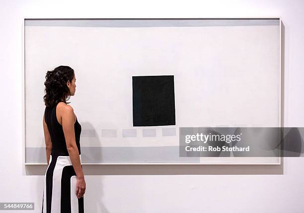 Member of staff poses for a photograph beside 'My Last Door' by American artist Georgia O'Keeffe at Tate Modern on July 4, 2016 in London, England....