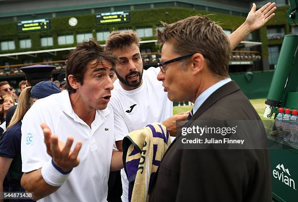 Pablo Cuevas of Uraguay and Marcel Granollers of Spain argue with the match referee during the Men's Doubles third round match against Jonathan...