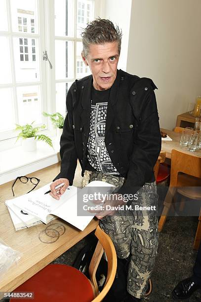 Judy Blame signs copies of "The House Of Beauty And Culture" by Kasia Maciejowska, edited by Gregor Muir, at the Dover Street Market on July 4, 2016...