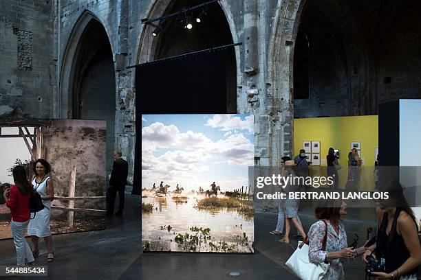 People visit the exhibition "Western Camarguais" as part of the photography festival "Rencontres de la photographie d'Arles 2016" in Arles, southern...