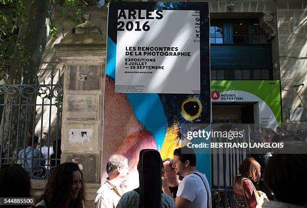 People stand outside the main office of the photography festival "Rencontres de la photographie d'Arles 2016" in Arles, southern France, on July 4,...