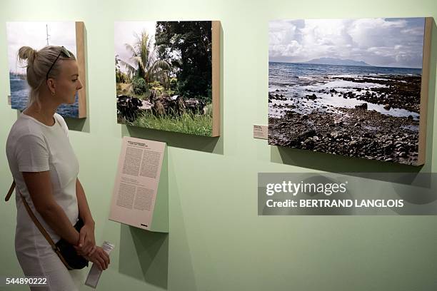 Woman visits the exhibition "Champs de bataille" by Yan Morvan as part of the photography festival "Rencontres de la photographie d'Arles 2016" in...
