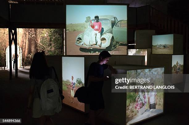 People visit an exhibition by Yann Gross as part of the photography festival "Rencontres de la photographie d'Arles 2016" in Arles, southern France,...