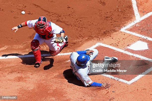 Prince Fielder of the Texas Rangers slides past Sandy Leon of the Boston Red Sox to score during the first inning at Fenway Park on July 4, 2016 in...