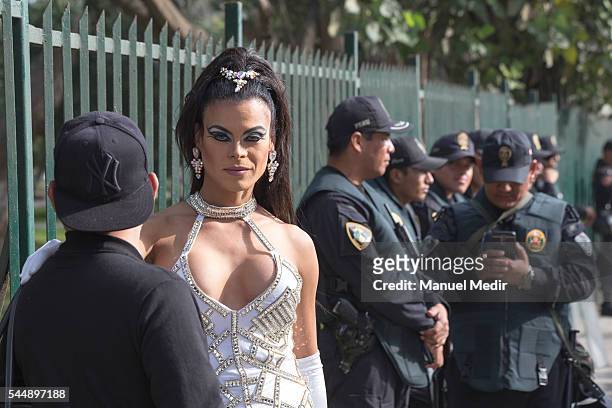 Drag queen stands near the police during a Gay Pride March at San Martin Square on July 02, 2016 in Lima, Peru.