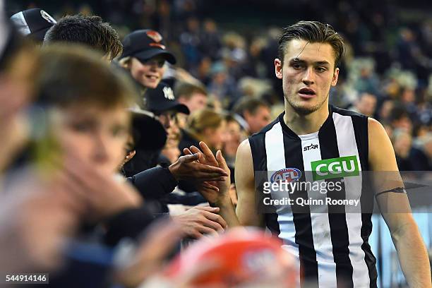 Darcy Moore of the Magpies high fives fans after winning the round 15 AFL match between the Carlton Blues and the Collingwood Magpies at Melbourne...