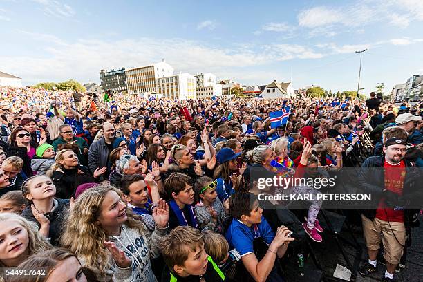 People greet Iceland national football team upon its arrival in Reykjavik on July 4, 2016 and celebrate the players as winners after they lost...