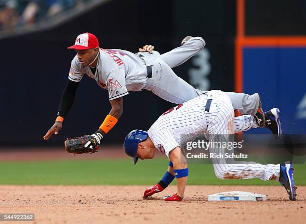 Brandon Nimmo of the New York Mets is safe at second base as he rolls into shortstop Adeiny Hechavarria of the Miami Marlins allowing Travis d'Arnaud...