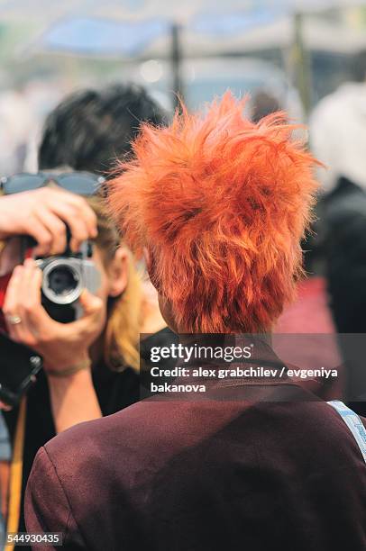 photojournalist takes a picture of the red-haired - photojournalist stock pictures, royalty-free photos & images