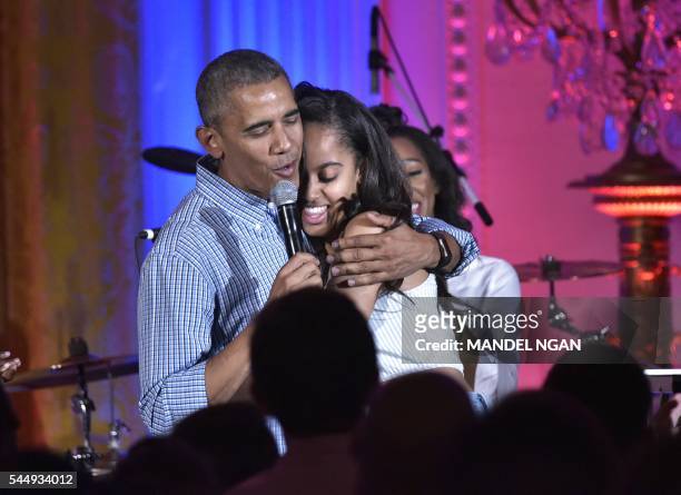 President Barack Obama hugs his daughter Malia on her birthday during an Independence Day Celebration for military members and administration staff...
