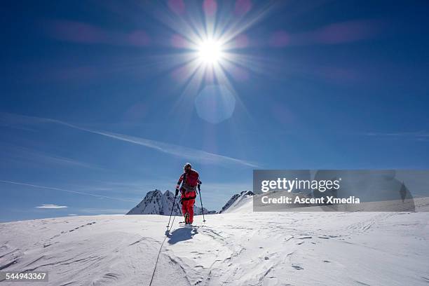 woman skis to snow crest above mountains - gebirgskamm stock-fotos und bilder