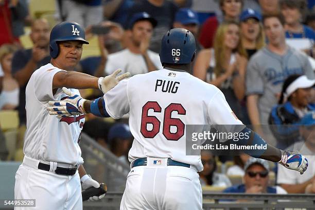 Yasiel Puig of the Los Angeles Dodgers is congratulated by teammate Will Venable after hitting a homerun in the second innng against the Baltimore...