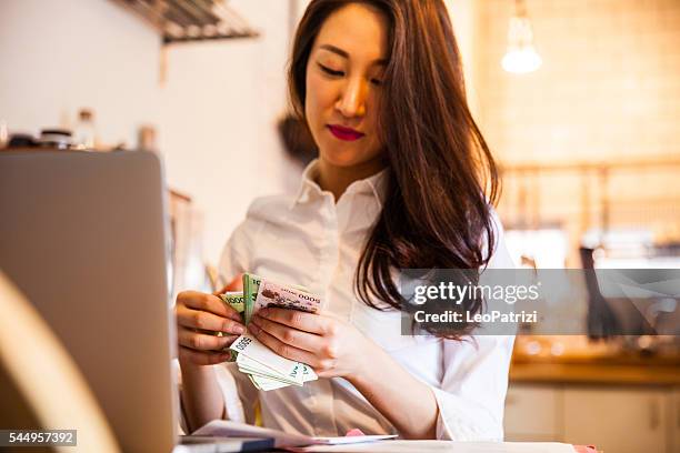 woman counting cash at home - korea apartment woman stock pictures, royalty-free photos & images