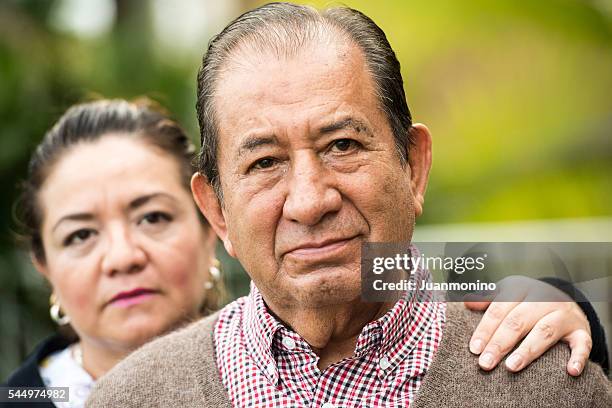 caring, hispanic nurse and elderly senior patient in nursing home - family serious stock pictures, royalty-free photos & images