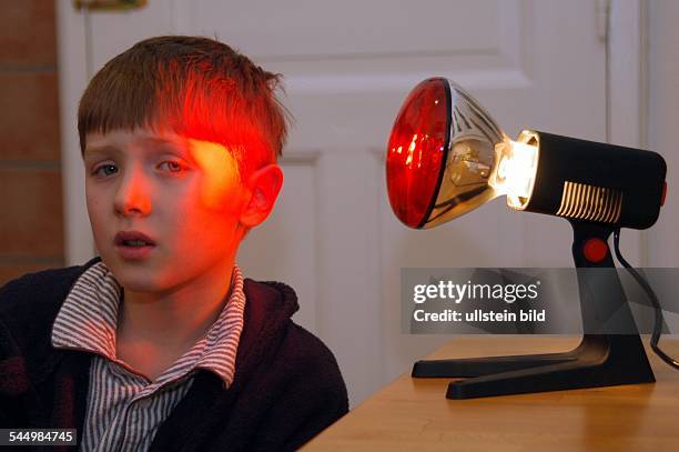 Germany - : boy in front od an infrared heat lamp -