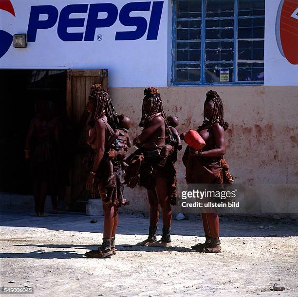 Drei junge Himba - Frauen in Opuwo vor einem Pepsi-ColaReklameschild- 1995 col